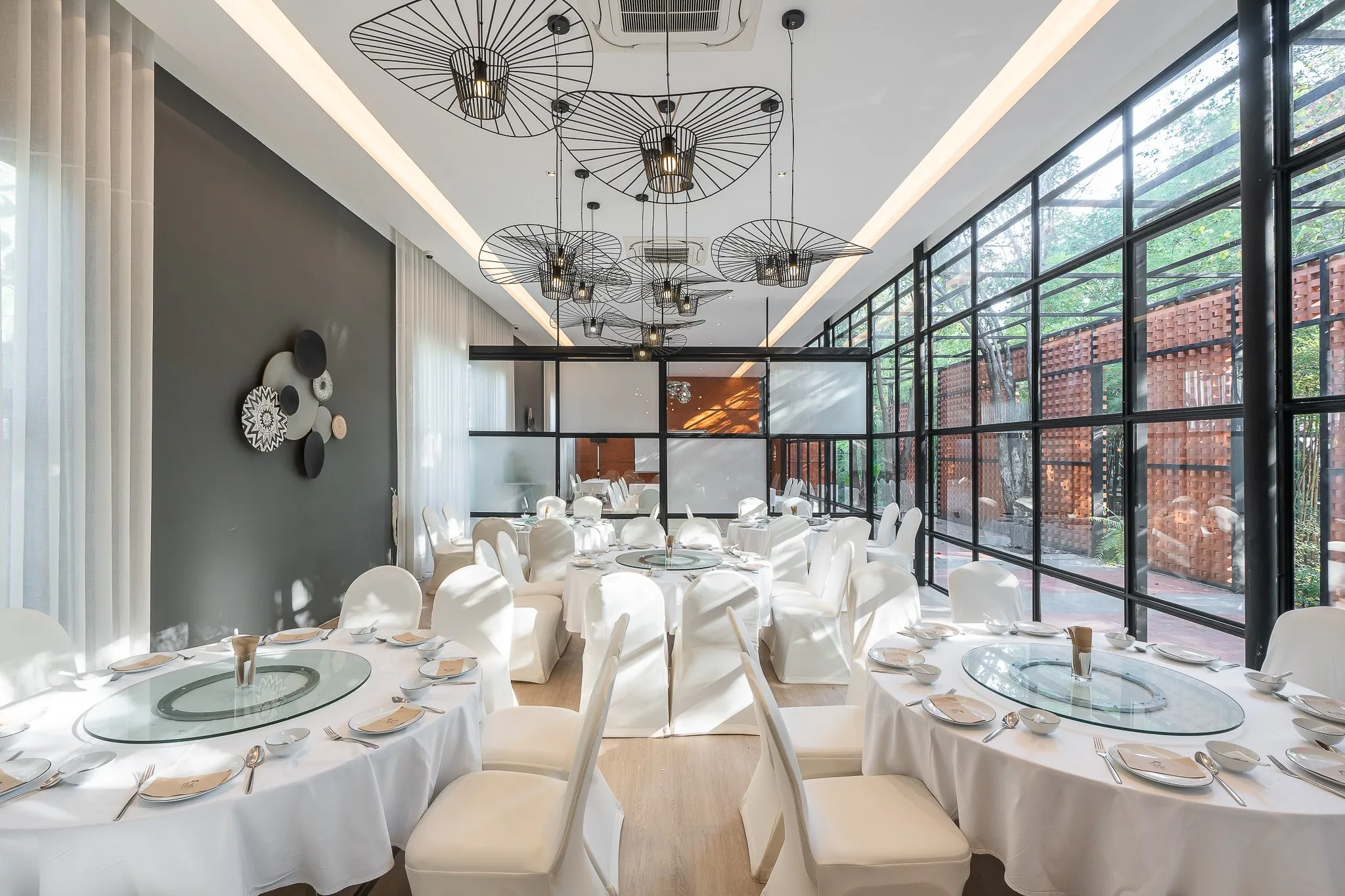 High-ceilinged banquet room with round tables