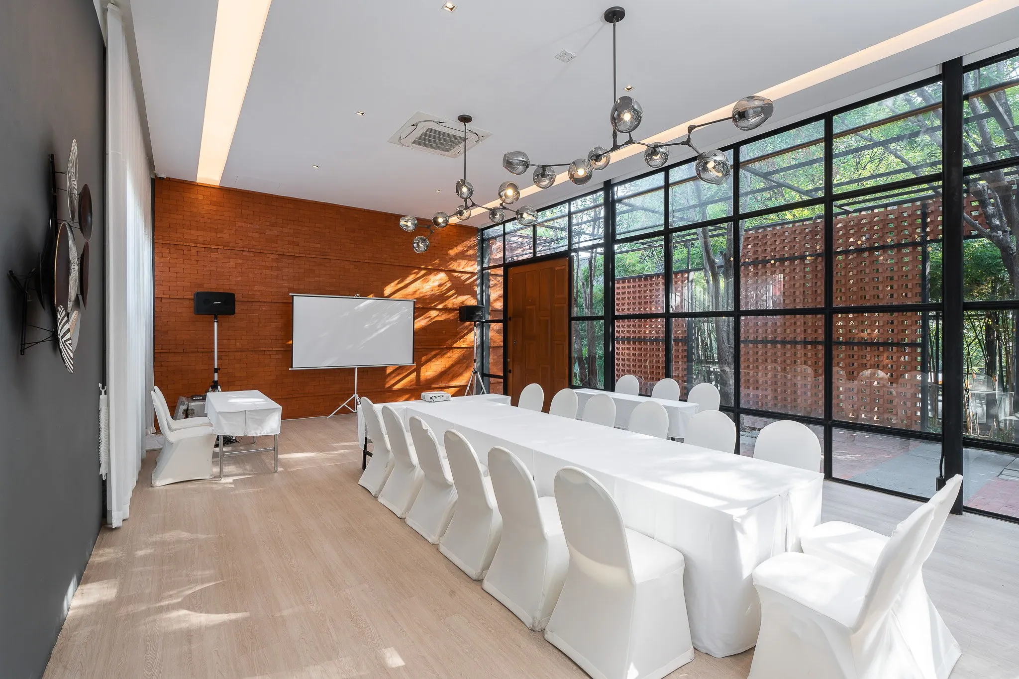 Meeting room with long tables and a brick wall